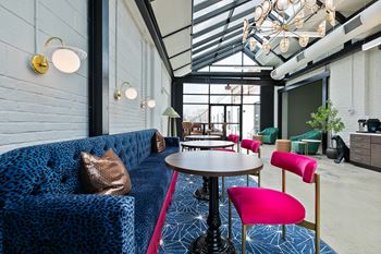 Lounge area with blue patterned sofa and pink chairs 1